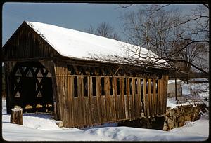 Covered bridge with snow on roof