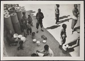 Group of children on the street, some painting bowls
