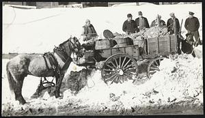 Two angles of a cart before the horse as James Watson of Roxbury works hard in South End to relieve his wagon out of a huge drift.
