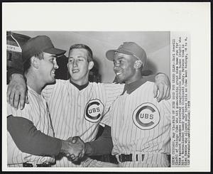 Chicago – Pair Of Aces Good For Grand Slam – Earl Averill (left) of Chicago Cubs who hit game-winning grand slam home run for team against Milwaukee yesterday congratulates Ernie Banks (right) who hit a bases-loaded homer against Cincinnati today. Between them is Glen Hobbie who allowed only three hits as Cubs beat Redlegs, 10 to 0.