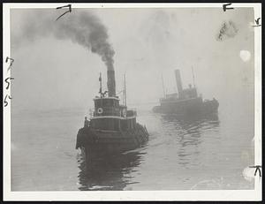 Defying Fog, the tugs Sadie Ross and Irving Ross are shown on their way to their berths at T wharf after aiding shipping which was halted in Boston harbor by the dense week-end fog.