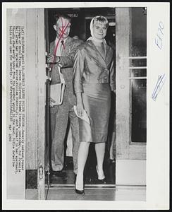 Beverly Leaves Police Station--Beverly Aadland, former protege of Errol Flynn, leaves Hollywood Police Station, yesterday, for Juvenile Hall after her rejected suitor. William Stanciu, 21, shot himself in her apartment. Stanciu died early today from the gunshot wound in the head. Police detective holds door open for Beverly.