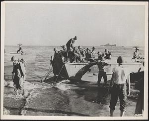 Troops of Americal Division land on beach of Guadalcanal without enemy opposition