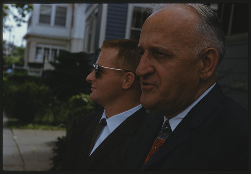 Two men standing outside a house