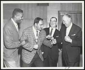 Champ-ing at the Bit Squaring Off against each other in mock battle are a couple former heavyweight boxing champions. Rocky Marciano, second left, is being held back by K. C. Jones of the champion Celtics, as he takes on Jack Sharkey. With the three champs are Raynham Park's general manager, Russ Murray. All three work on the Raynham publicity staff.