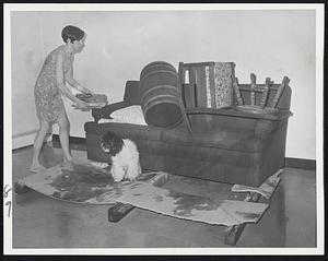 Water flooding into apartment building in Newton forced Mrs. Edward Tely to use timber and couch to keep some things dry.