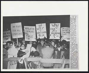 Pickets Wave Placards at President-Pickets carrying a variety of protest signs, stand behind barriers on Broad street in Philadelphia tonight as President Kennedy arrived at a hotel on the opposite side. The President came to Philadelphia to campaign for Mayor James H.J. Tate, seeking election in next Tuesday's election.