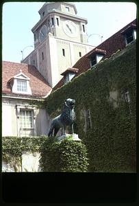 Sculpture of animal surrounded by ivy covered building