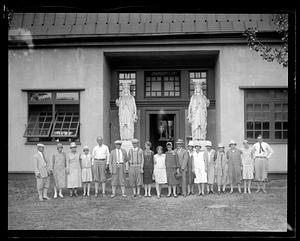 A group of people posing in front of a building with two caryatids in front