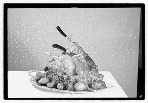 Carving knife and fork in cooked turkey