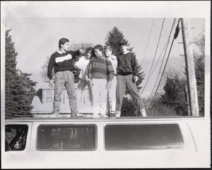 Val Postell, Giselle Santiago, Kyle Postell, Sabina Postell and Jimmy Driscoll standing on top of a van