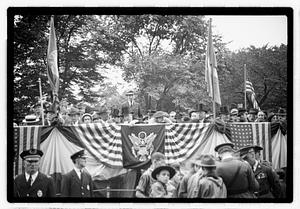 A group of people seated on a reviewing stand including Boston Parks Commissioner William Long