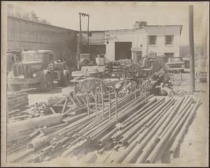 Pipes and vehicles in yard at Clark-Aiken