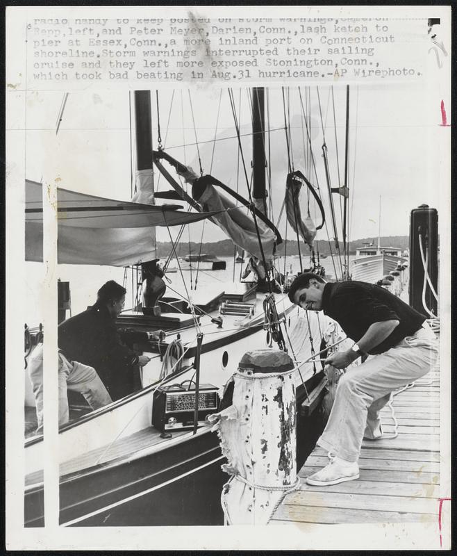 Repp, left, and Peter Meyer, Darien, Conn., lash ketch to pier at Essex, Conn., a more inland port on Connecticut shoreline. Storm warnings interrupted their sailing cruise and they left more exposed Stonington, Conn., which took bad beating in Aug. 31 hurricane.