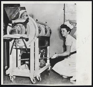 Nurse Angela Bates hand-pumps an iron lung at Mt. Sinai Hospital during massive power failure in New York City yesterday. The patient is Philip Konigsberg, 8.