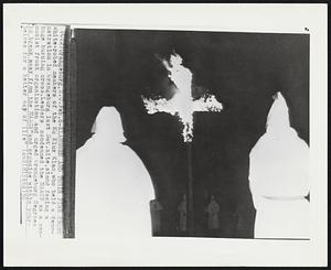 Klansmen and Their Fire Cross White-robed members of the Ku Klux Klan, who held a demonstration in Orangeburg last Sat. nite, stand facing a huge burning cross. Leaders condemned the NAACP as a communist front organization and urged Orangeburg Negroes to break away from the NAACP "and organize within yourselves for a better way of life"