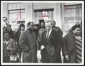 Cooling Session - Mayor Kevin White and Councilman Thomas Atkins outside the Welfare Department's Tremont St. building following a conference with welfare mothers seeking special funds to purchase Easter clothing for their children.