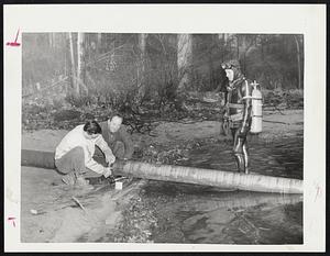 Scuba Diver [illegible] Farnsworth, chief of the Leominster Civil Defense divers, and workers [illegible] [w]ater pipe that will carry water from Whalom lake. Some 2 million gallo[ns] [illegible] are available from the lake for about 100 days to alleviate water shortage [illegible] drought in the area.