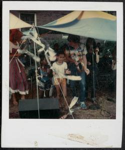 Adults and children playing tambourines and singing