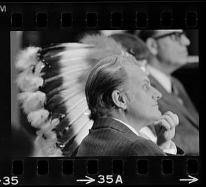 Billy Graham juxtaposed with Indian head dress, Plymouth