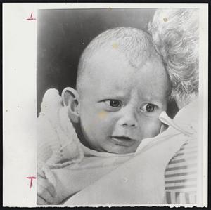 Orphaned by Hurricane-Four-month-old Nancy Thorpe of Toronto, who was orphaned after losing her mother, father, brother and grandmother in flood waters caused by Hurricane Hazel last week. The baby was handed to Fire Chief Houston, who carried her across the street. Before he could return to aid the rest of the family the house with all the family was swept away by flood waters.