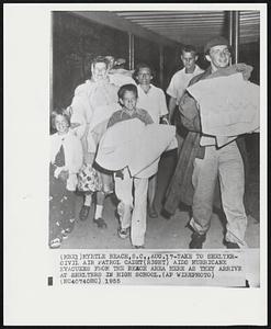 Take to Shelter - Civil Air Patrol cadet (right) aids hurricane evacuees from the beach area here as they arrive at shelters in high school.