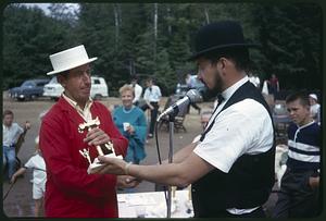 Bicentennial emcee presenting a trophy to a man at the antique car rally