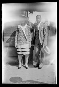 A man and woman stand posing