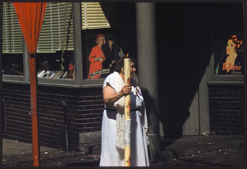 Woman holding tall lit candle