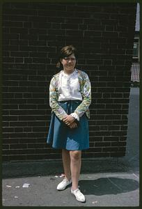 Girl standing in front of brick wall