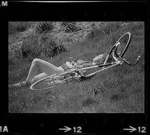 Person and bicycle lying in grass