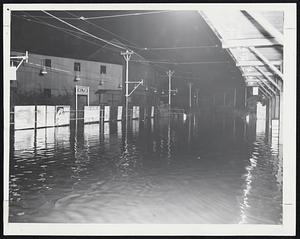 No Train Today-The Milton M. T. A. station stands quiet as water from the swollen Neponset river covers the tracks into the station. The river overflowed about 2 P. M. yesterday when a high tide held back its flow.