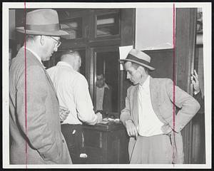 Surrender to Police. Douglas P. Adams, 37 (right) being booked at Police Headquarters shortly after surrendering to County Attorney Frederic S. Sturgis in Portland, Me., June 14th after being sought for five days. Sturgis said Adams calmly described how he slashed his wife, Charlotte, 38, and daughter Carolyn, 12, to death a week ago because he couldn't provide for them. Adams told officials he took an early train to Boston after the slaying and continued to New York. He told police he decided to give himself up after spending several hours in the "meditation room" at the United Nations building. An unidentified FBI agent (left) watches the booking.