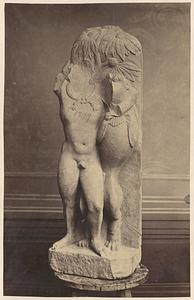 View of damaged sculpture of person and bird-like creature, on stool indoors, front view