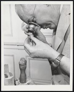 Cleaving the Libertador New York - Adrian Grasselli, who did the cleaving in the office of Harry Winston, jewel merchant who owns the $200,000 gem, looks at the diamond cut in two. He did a perfect job; one part is still embedded in the shellac, while he looks at the other half.