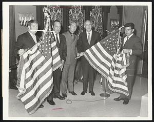 Graduating Apprentices in the training program conducted by Local 4, Operating Engineers Union, AFL-CIO, present American flags officials of the union at graduation exercises. Walter J. Ryan, second right, accompanied by his son, Walter Jr., accepts one flag from James Trainor of Medway. At left, Robert McCallum of Cambridge presents flag to James Grande, Local 4 apprenticeship director.