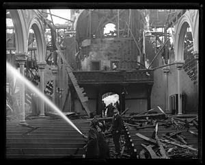 Firefighters and police looking above inside a church after a fire, possibly the First Parish in Waltham Unitarian