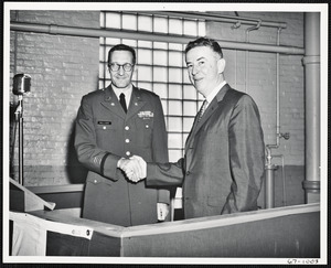 Col. Kellogg shaking hands with man