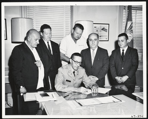 Col. Kellogg signing document