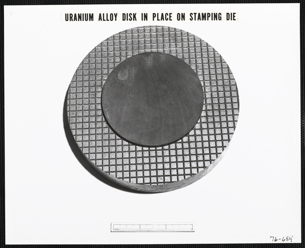 Uranium alloy disk in place on stamping die