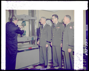 Man demonstrating machine to three officers