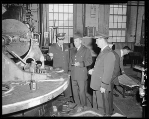 Military officers observing machinery