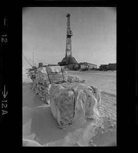 Supplies for BP Alaska oil operation, derrick in background