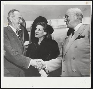 President Greets Acheson--President Truman (right) welcomes Secretary of State Acheson home from cold war talks in Europe. Mrs. Acheson stands with them at the National Airport in Washington.