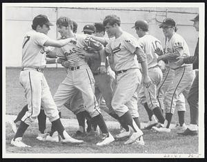 Our Hero - Lynn Classical catcher Mike Carroll, second from left, gets the hero's treatment from teammates after socking two-run homer in eighth inning of 6-1 victory over Somerville at Lynn.