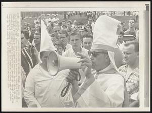 Robed Speaker Addresses Crowd--Man clad in Ku Klux Klan type robes uses bullhorn to address crowd in Marquette Park Sunday following rally staged by American Nazi Party. He was arrested for speaking without a permit and identified himself as Evan Lewis, 34, of Akron, Ohio. Park was scene of violent racial clashes earlier this summer.