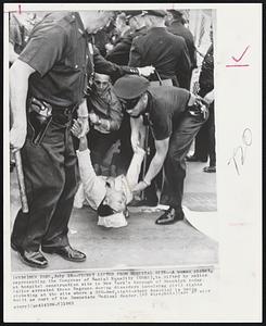 New York – Picket Lifted From Hospital Site – A woman picket, representing the Congress of racial Equality (CORE), is lifted by police at hospital construction site in New York’s borough of Brooklyn today. Police arrested three Negroes during disorders involving civil rights picketing at the site where a 350-bed, eight-story hospital is being built as part of the Downstate Medical Center.