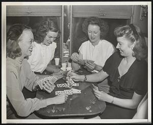 Wives of Redbirds Enroute to Sixth Series Game Four of the most enthusiastic rooters for the St. Louis cardinals, wives of Redbird players, are shown whiling away the time by playing cards on the train that took them to St. Louis where their husbands will play in the sixth game of the 1946 world series. Left to right are- Mrs. Jeff Cross, Mrs. Clyde Klutz, Mrs. Fred Schmidt and Mrs. Red Barrett.