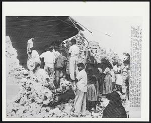 Mexico City -- Watch Rescue Operations -- A group of persons watch rescue operations in what was left of a house destroyed by a strong earthquake at this village of Coyuca de Catalan in the state of Guerrero where at least thirty one persons are reported killed.