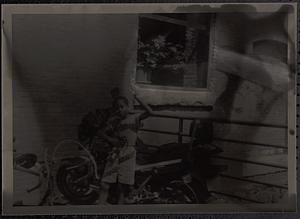 Boy posing in front of a railing and window